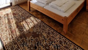 Ein Schlafzimmer mit einem großen Bett, einem Holzkopfende, einem Gemälde an der Wand und einem gemusterten Teppich.