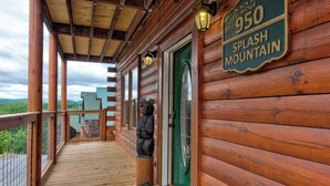 Una cabana de fusta amb un porxo, un senyal que diu "950 Splash Mountain" i una vista del paisatge circumdant.