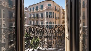 A view from a balcony with ornate iron railings, overlooking a row of classical buildings with balconies and shutters. - Solaga Souviron Suits (Málaga)