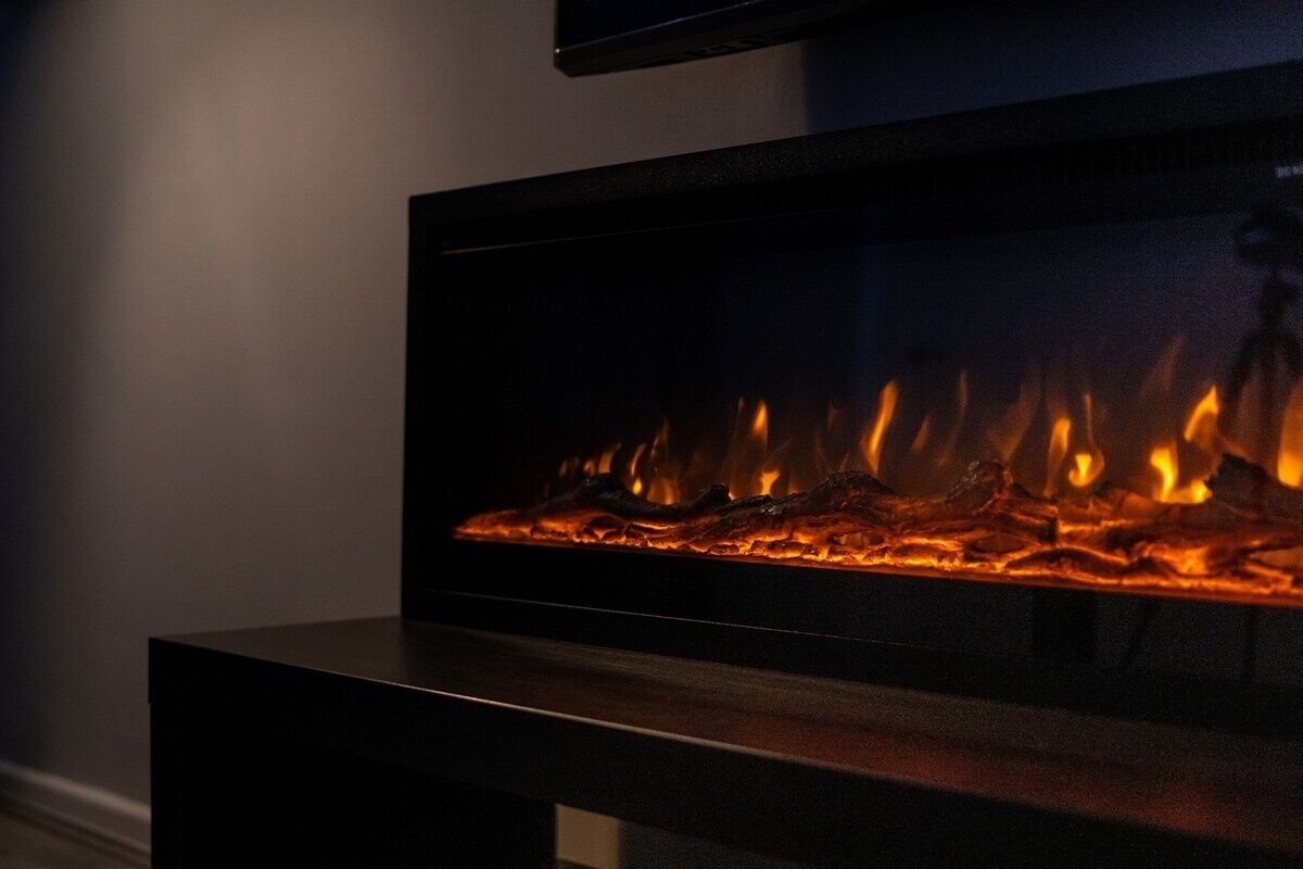 Een moderne haard met zichtbare vlammen, een flatscreen televisie erboven en een donkerkleurige tafel ervoor.