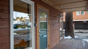 A wooden building with a glass door and a wooden porch. - #9 New! 3 bedroom Apartment in Town (Mammoth Lakes)