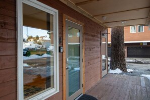 Ein Holzhaus mit Glastür und einer Holzveranda.