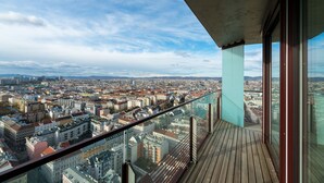 A high-rise balcony with a city view, featuring a wooden deck and glass railings. - Vienna Residence, Donaukanal - Landstraße #6450 (Vienna)