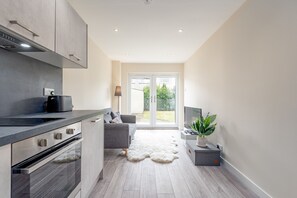 A modern kitchen with grey cabinetry, a built-in oven, and a black range hood.