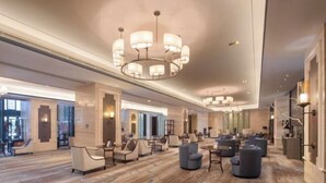 A spacious hotel lobby with multiple seating areas, a grand chandelier, and a modern interior design. - Jing Jiang Hotel (Lianjiang)