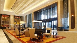 A spacious lobby with a grand piano, comfortable seating, and large windows offering views. - Jing Jiang Hotel (Lianjiang)