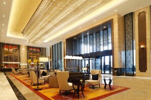 A spacious lobby with a grand piano, comfortable seating, and large windows. - Jing Jiang Hotel (Lianjiang)