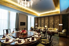 A conference room with a round table, chairs, and a chandelier. - Jing Jiang Hotel (Lianjiang)