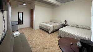 Un dormitorio con cama, mesita de noche, lámpara y un escritorio pequeño con silla.