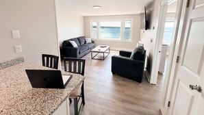 A modern living room with a sofa, a coffee table, and a laptop on a granite countertop. - Saratoga Lakeside Retreat #3 (Saratoga Springs)
