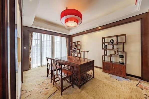 A room with a wooden dining table, chairs, a red chandelier, a decorative cabinet, and a patterned carpet. - Luling Hotel (Ji'an County)