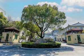 A building with a large tree in the center, surrounded by a circular garden. - Luling Hotel (Ji'an County)
