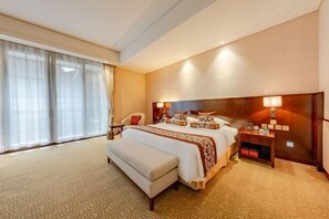 A hotel room with a large bed, a bedside table, a bench, a nightstand, and a window with sheer curtains. - Luling Hotel (Ji'an County)