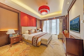 A hotel room with a large bed, a nightstand, a TV, and a view of the outdoors. - Luling Hotel (Ji'an County)