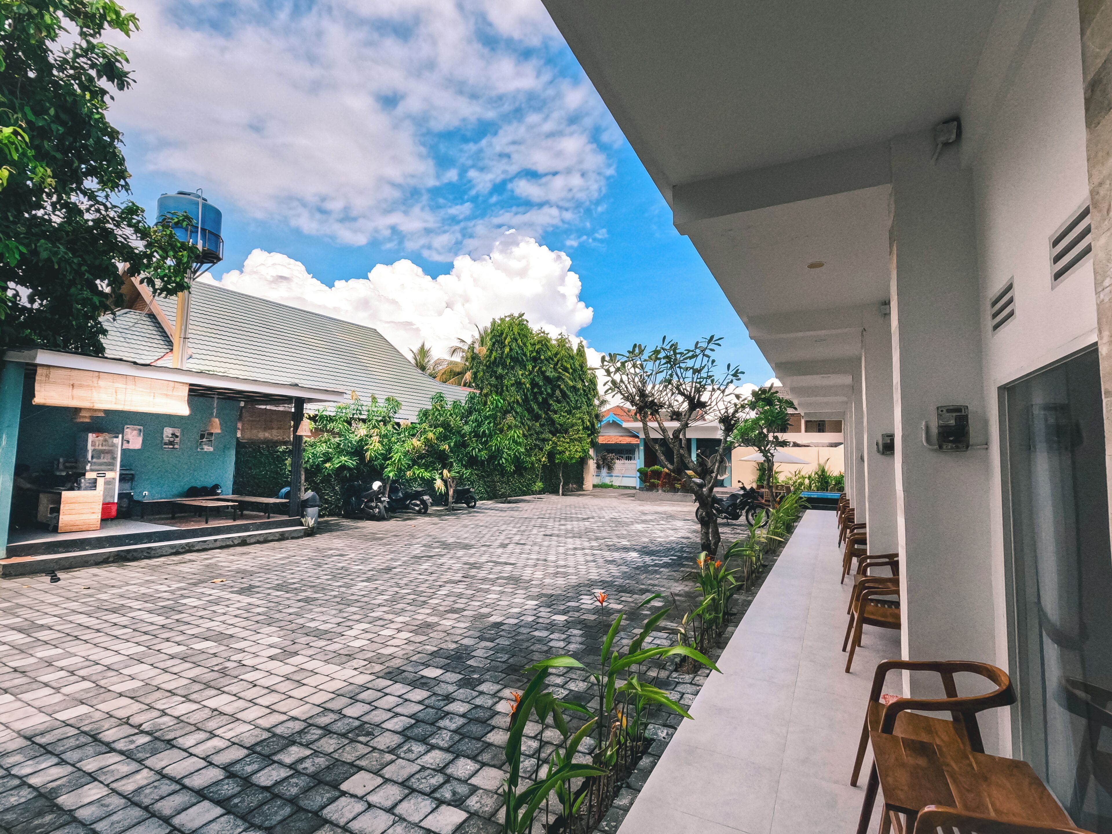 A courtyard with a paved floor, outdoor seating, and a water tank in the background.