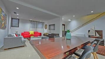 A modern living room with a wooden coffee table, a red sofa, a grey sofa, and a pineapple decoration.
