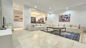 Een moderne woonkamer met een hoekbank, een salontafel en een kamerbreed tapijt.