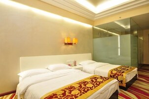 Habitación de hotel con dos camas, un espejo grande y una alfombra roja.