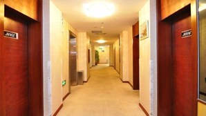 Um corredor de hotel com portas de madeira, cada uma identificada com um número de quarto.