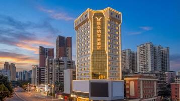 A multi-story hotel with a prominent vertical sign, surrounded by other high-rise buildings.