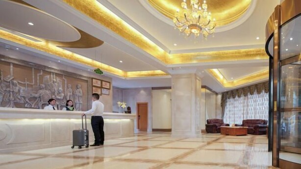 A hotel lobby with a reception desk, a chandelier, and a seating area with sofas. - Vienna Classic Hotel(Westlake Honghua Lake Scenic Area Branch,Huizhou) (Huizhou)