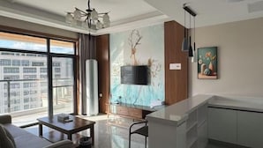 Un soggiorno moderno con divano, tavolino e televisore montato a parete su un affresco.