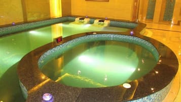 A hot tub with a tiled edge and a control panel.