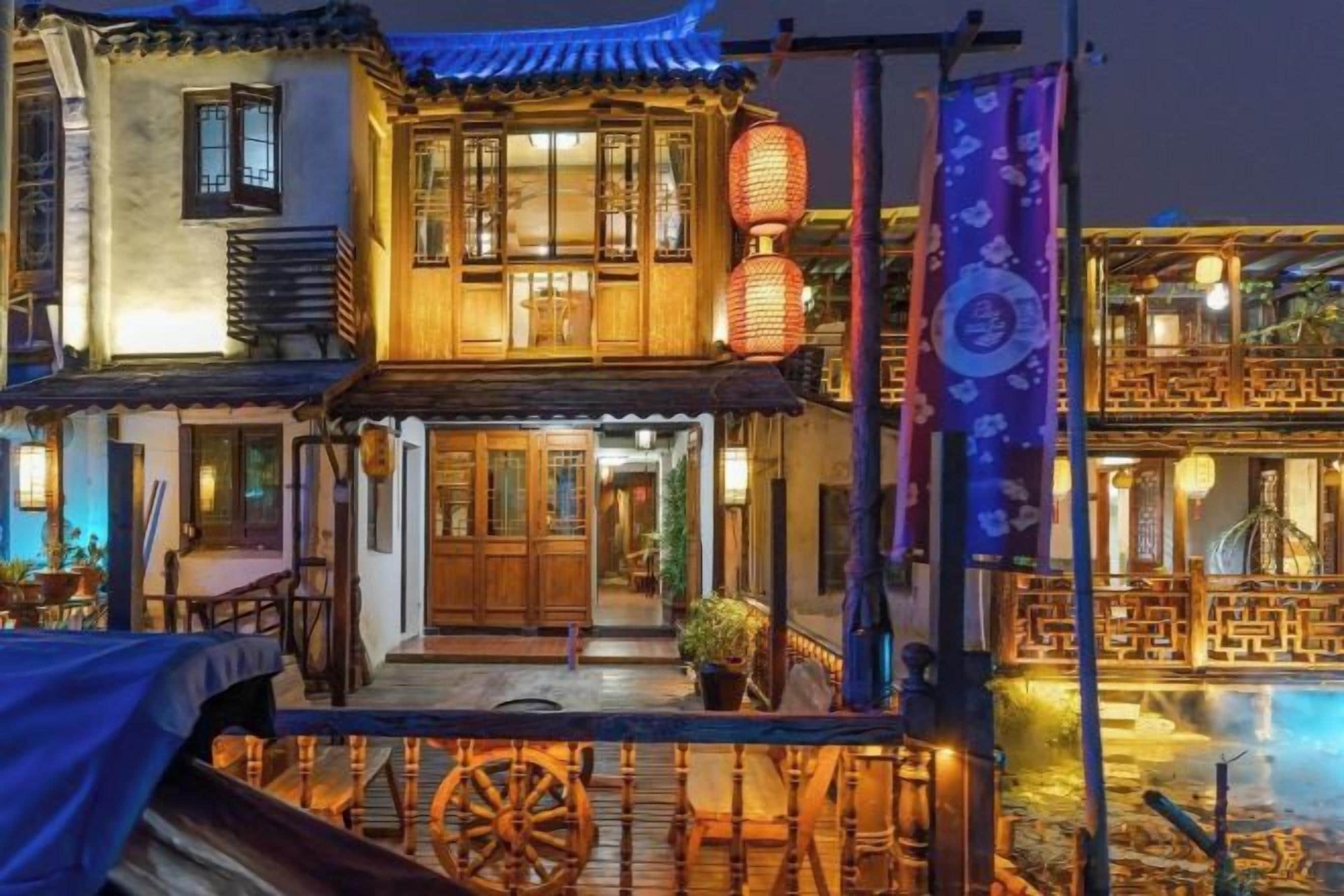 Een klassiek pand met een houten balkon, een grote houten deur en een lantaarn.