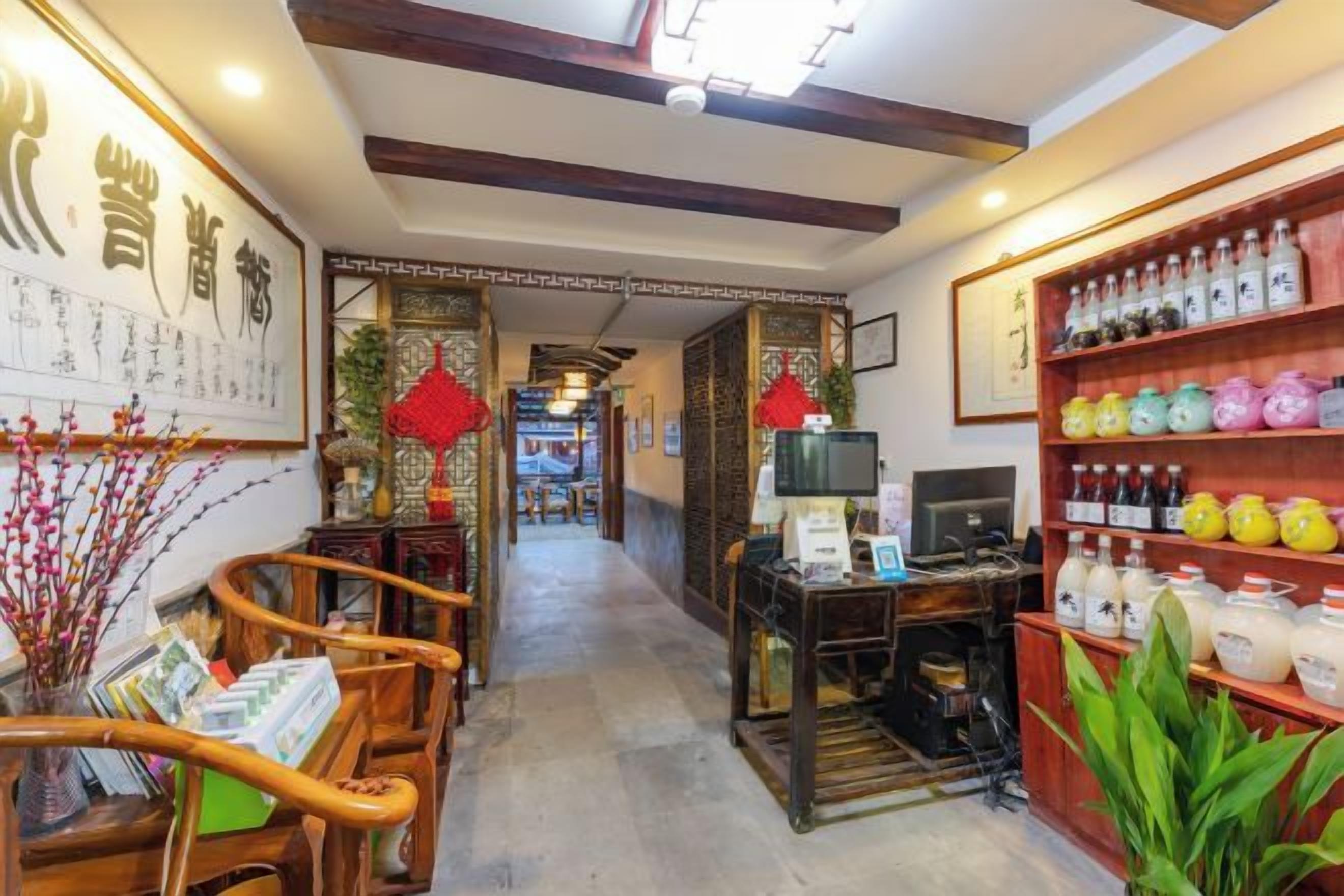 Un intérieur traditionnel avec des meubles en bois, un comptoir d’accueil et des étagères remplies de bouteilles.