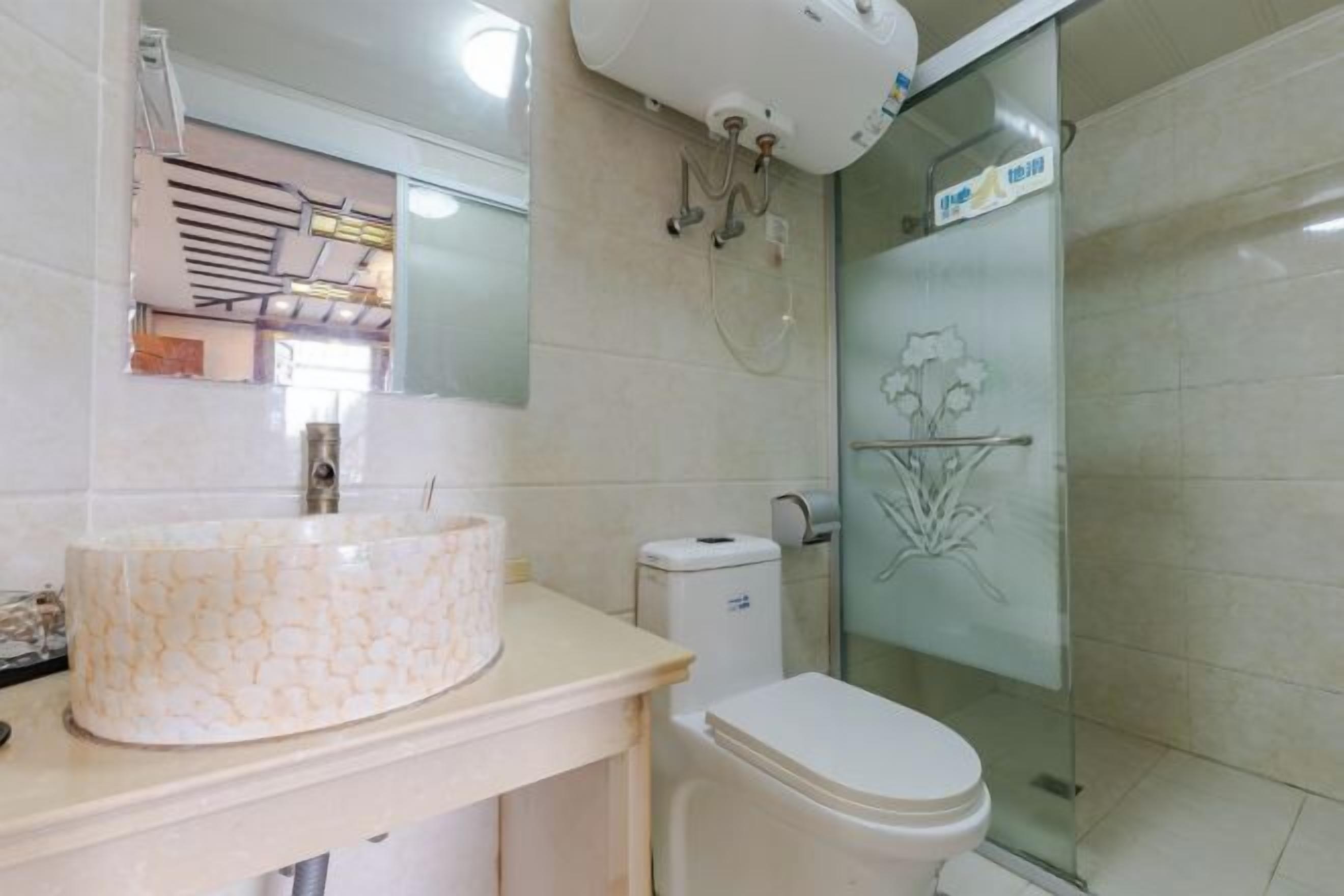 Een badkamer met toilet, wastafel en douchecabine.