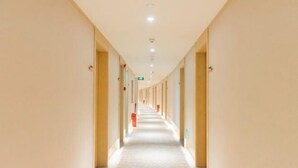 A long, narrow hotel corridor with a light-colored floor and walls, and a series of doors on one side. - JI Hotel (Fuzhou Gushan Fuma Road) (Fuzhou)