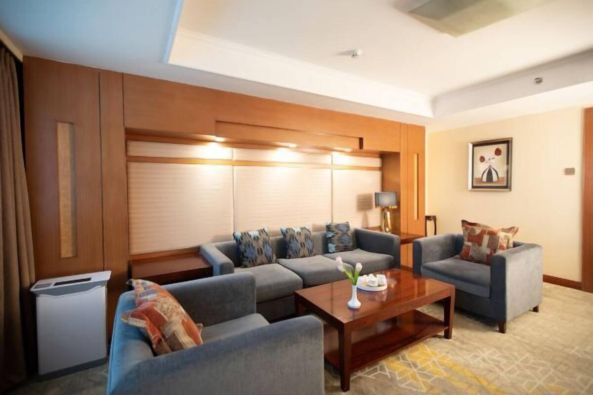 A modern living room with a sofa set, a coffee table, and a lamp.