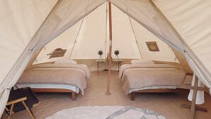 A tent with two beds, a fan, and a rug. - Burhan Wilderness Camps (Manjhara)