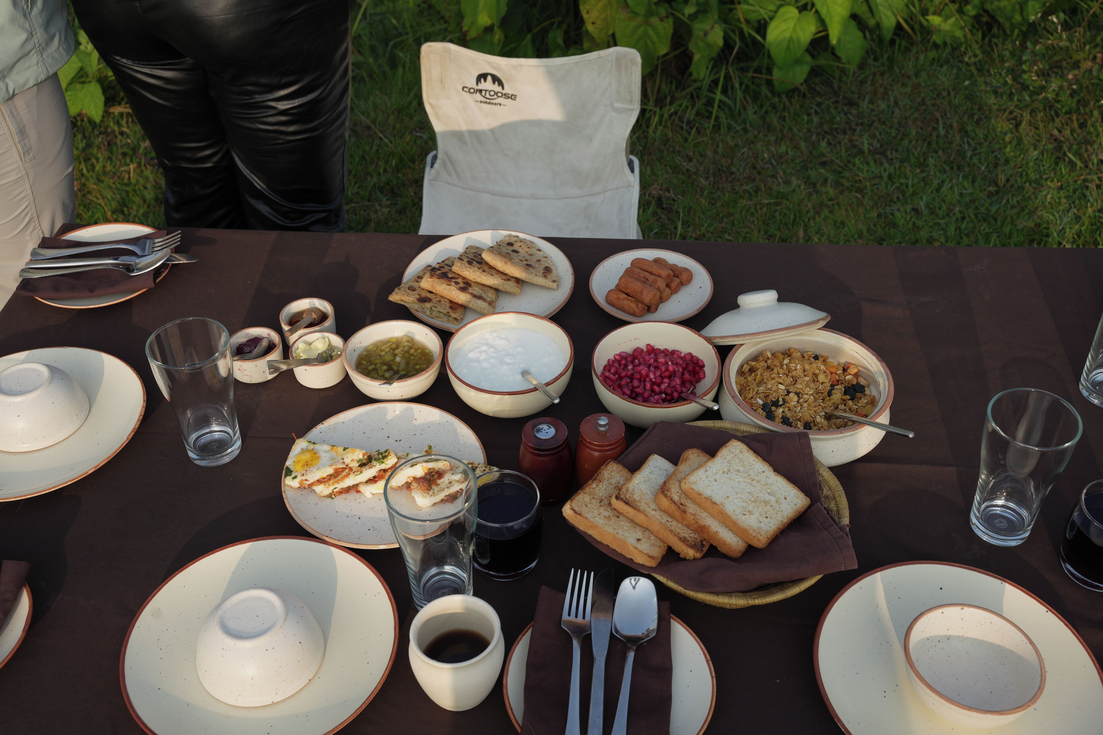Una mesa dispuesta para una comida con diversos platos, incluyendo pan, semillas de granada y un tazón de sopa.