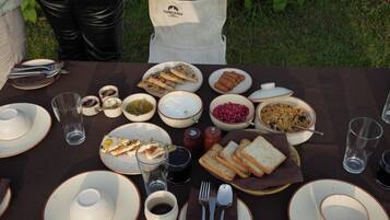 Una mesa dispuesta para una comida con diversos platos, incluyendo pan, semillas de granada y un tazón de sopa.