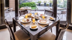 A dining area with a table set for breakfast, including plates of food, drinks, and cutlery. - Jinjiang Inn - Boracay Station 1 (Boracay Island)