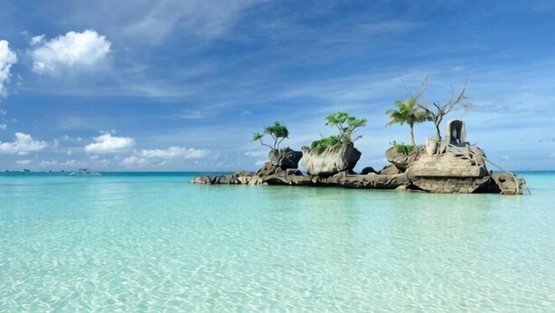 A clear turquoise sea, a rocky island with sparse vegetation, and a clear sky. - Jinjiang Inn - Boracay Station 1 (Boracay Island)