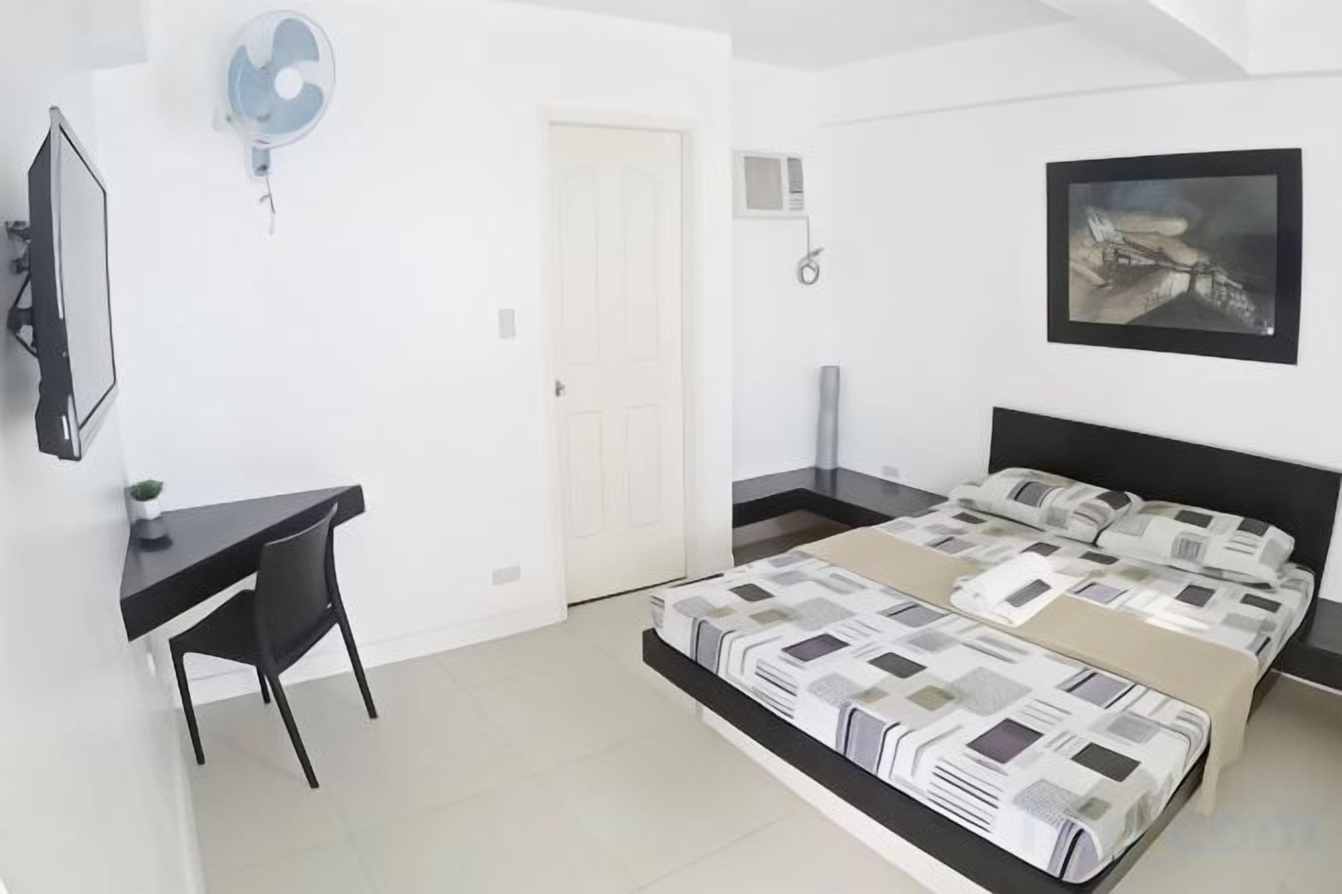 Une chambre à coucher avec un lit, un bureau et une chaise.