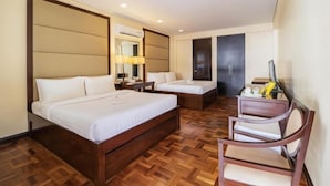 A hotel room with two beds, a wooden floor, a desk with a chair, and a TV. - Jinjiang Inn - Boracay Station 1 (Boracay Island)