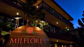 A hotel entrance with a sign reading "MilFLORES Deboracay" and a balcony with railings. - Jinjiang Inn - Boracay Station 1 (Boracay Island)