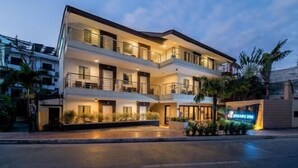 A multi-story hotel with a modern design, featuring balconies and a well-lit entrance. - Jinjiang Inn - Boracay Station 1 (Boracay Island)