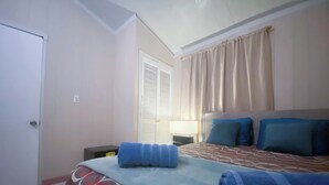 A bedroom with a bed, a nightstand, a lamp, and a door. - Sol Springs Estate (Osbourn)