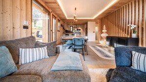 Ein modernes Interieur mit Holzwänden, einem Essbereich und einem Kamin.