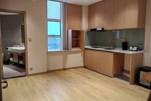 Eine moderne Küche mit Holzschränken, einer Arbeitsplatte und einem Fenster.