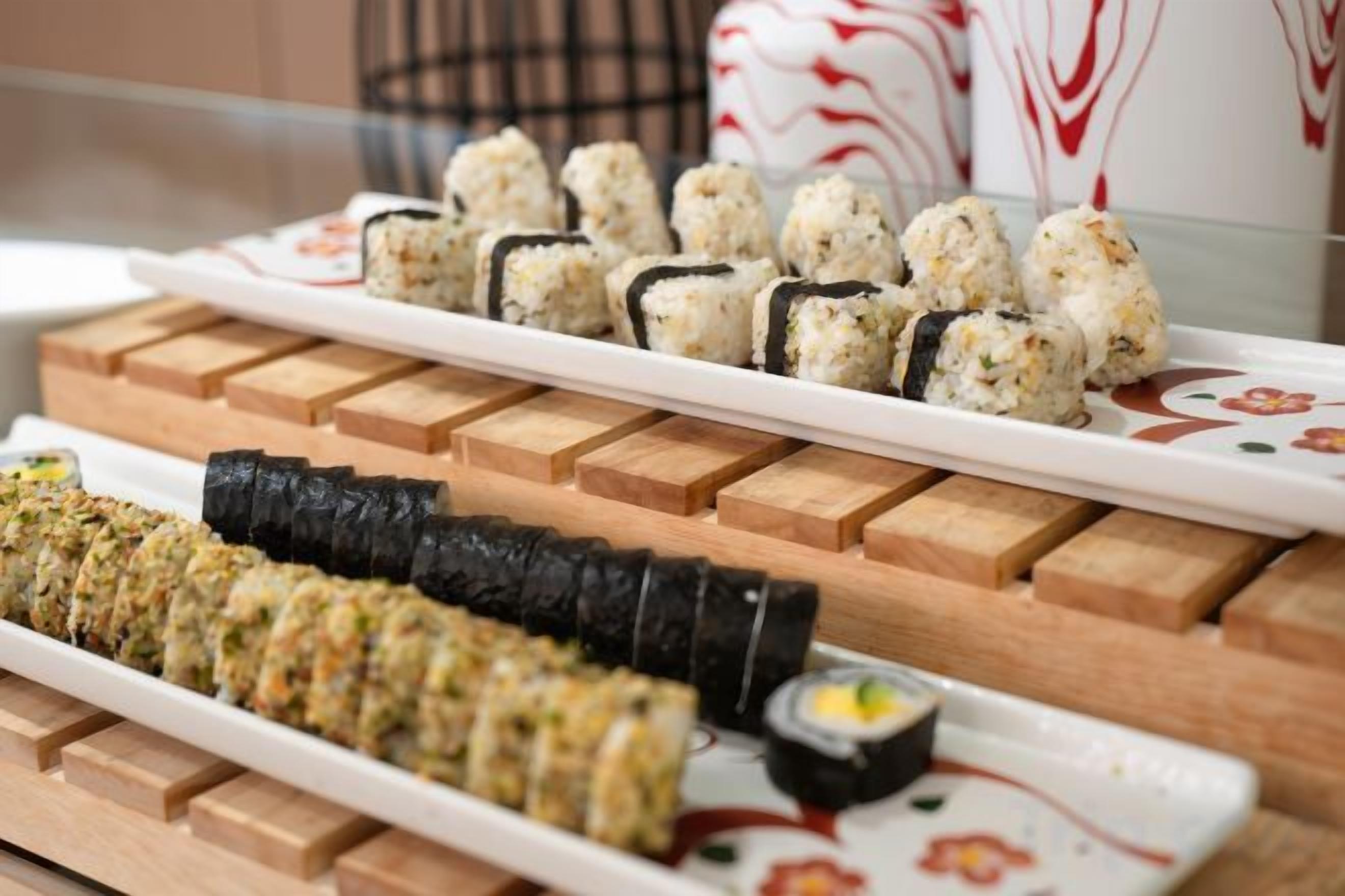 A variety of sushi on wooden trays.