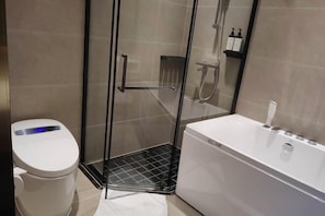 A modern bathroom with a toilet, a glass-enclosed shower, and a white bathtub. - Guomao Boutique Hotel (Zhangjiagang)