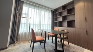Uma sala de conferências com mesa, cadeiras, um radiador e uma estante grande.