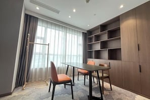 Un salón de conferencias con una mesa, sillas, un radiador y un estante grande.