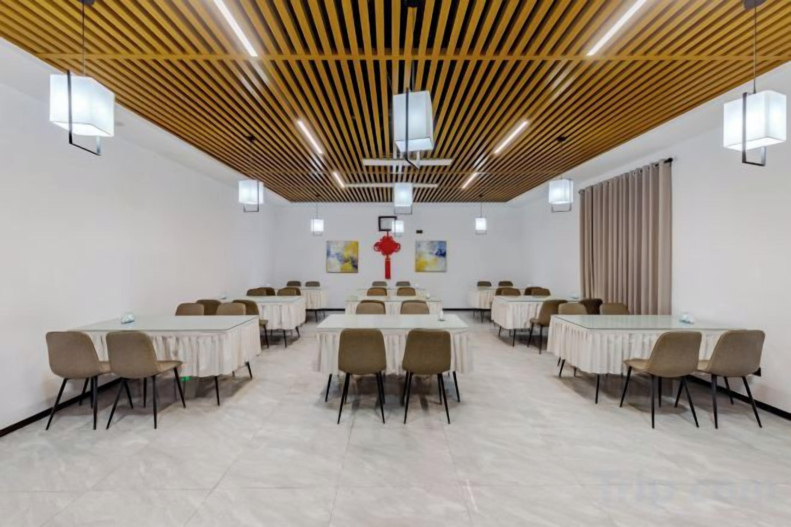 A conference room with a long table, chairs, and a wooden ceiling.