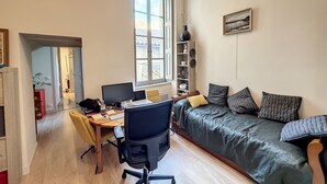 Un espace de vie compact comprenant un bureau, un ordinateur et un canapé.